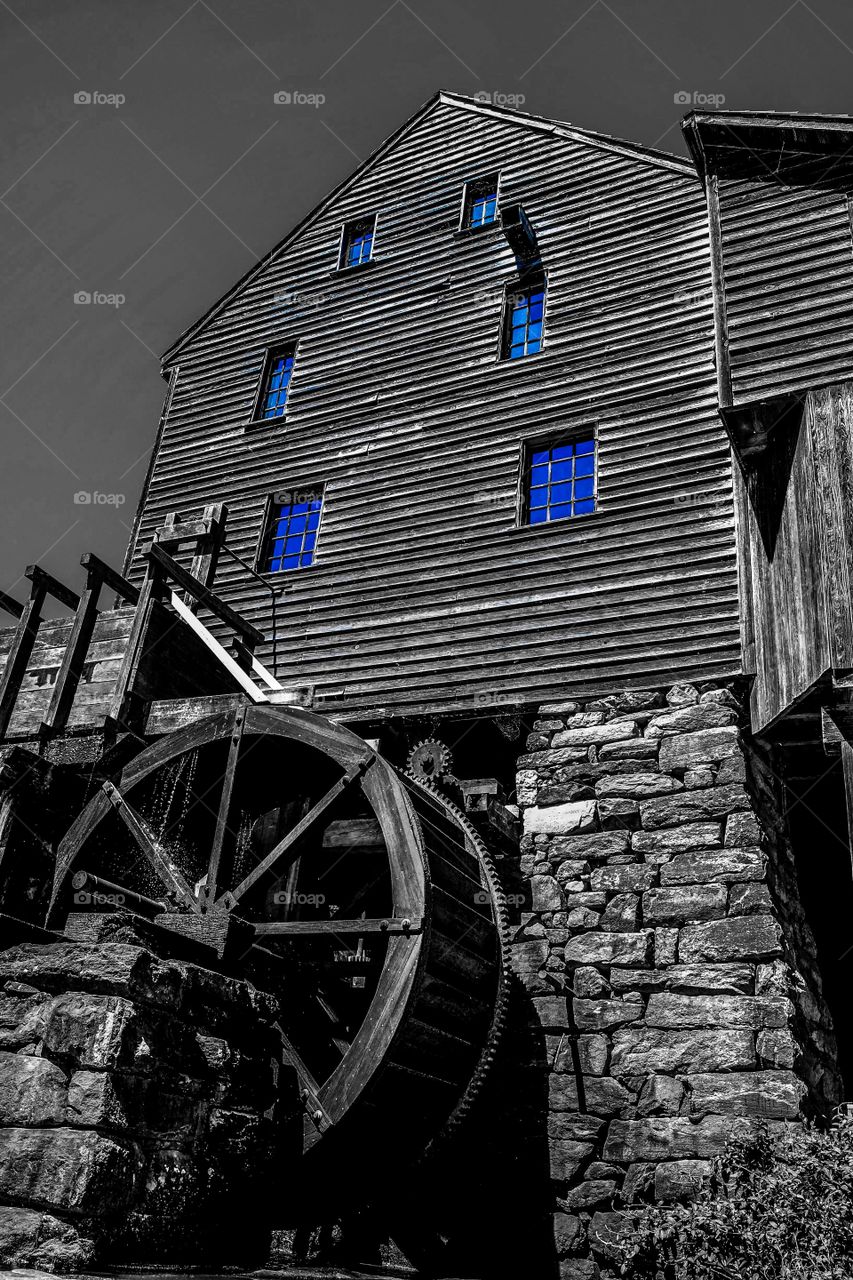 Color pop or color splash of the sky reflecting in the windows of the old gristmill or watermill at Historic Yates Mill County Park in Raleigh North Carolina, Triangle, Wake County. 