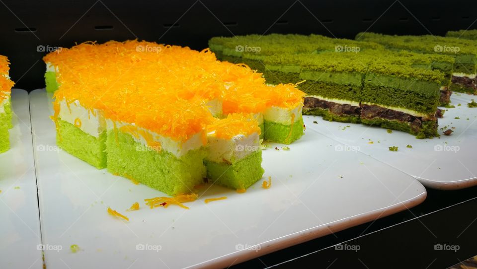Orange cake with green matcha sponge on display.