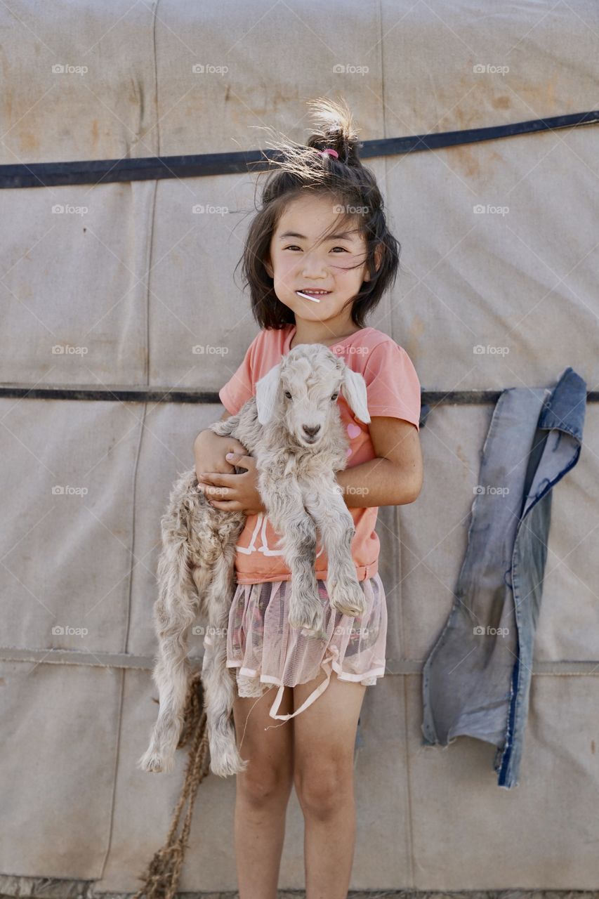 Mongolia girl and her baby lamb