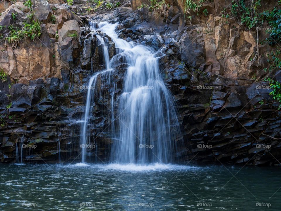 A waterfall on the island of Maui feeds into a beautiful lagoon on the tropical side of the island