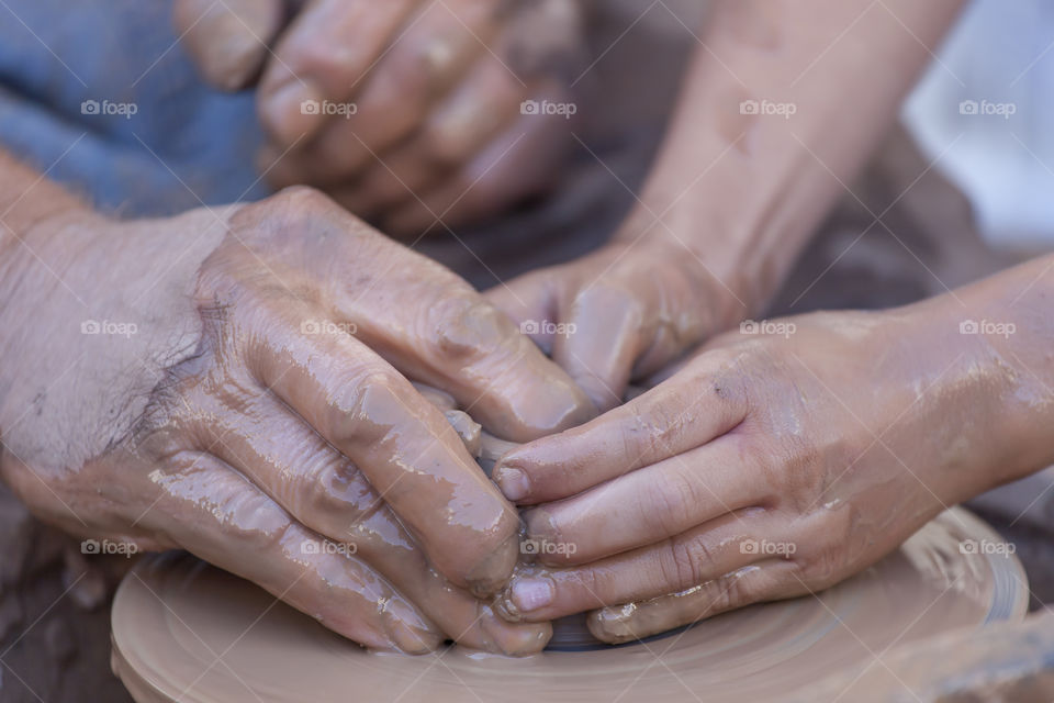 Close-up of two people making pottery