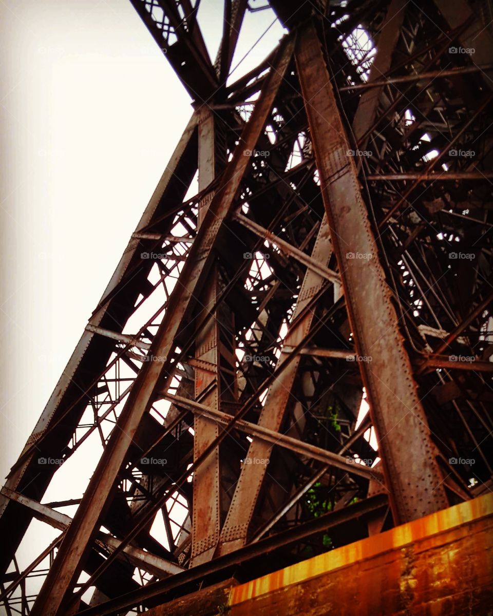 Rusty bridge supports rise up in a structural pattern.