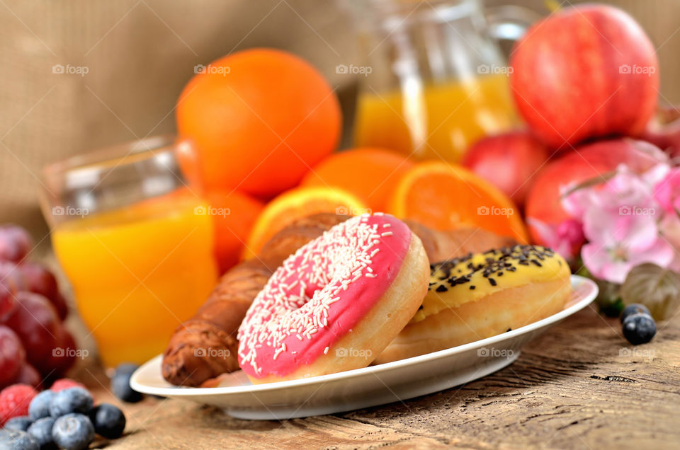 Sweet breakfast, donuts, croissant, fresh orange juice