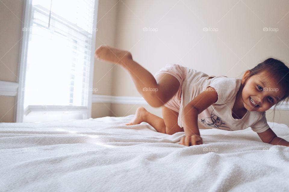 Little girl posing on bed