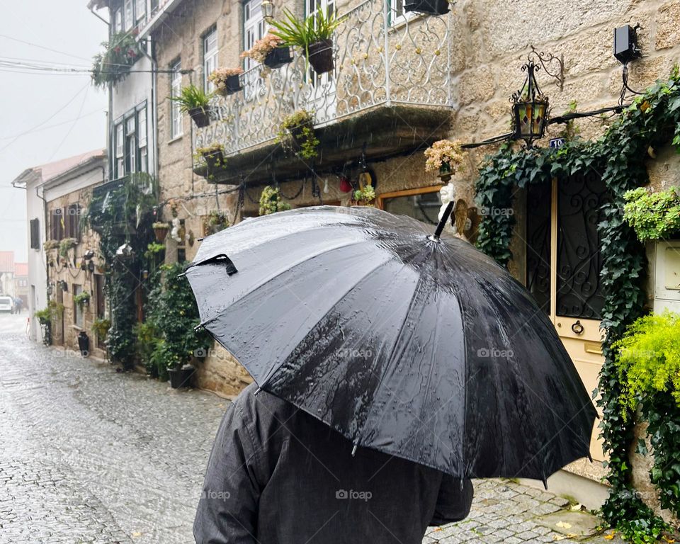 Rain with black umbrella in Belmonte Portugal 