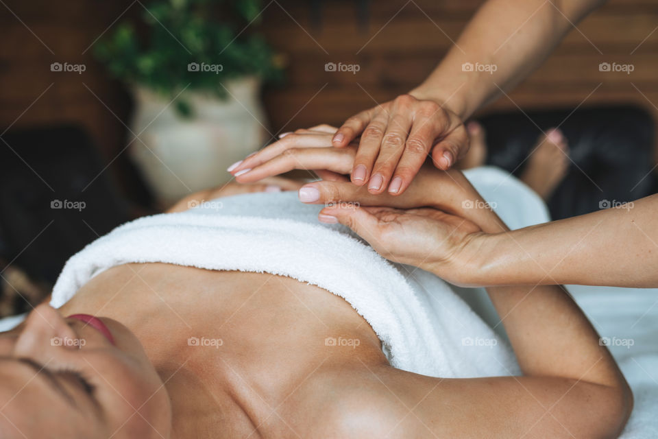 Young woman gets hands massage in spa beauty salon 