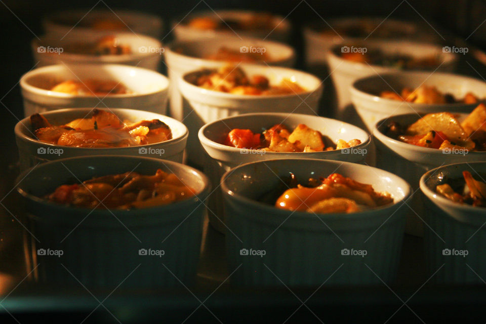 Small bowls of food in lighted oven