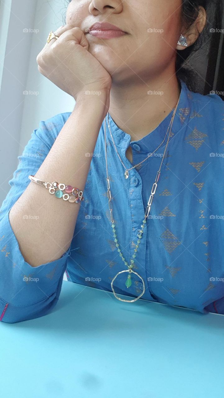 women with colourful bracelet to her hand and beautiful green neck chain