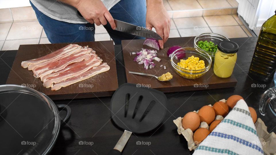 Homecooking cooking Frittata at home and adding and mixing ingredients and removing the Frittata from the pan for cutting and serving on a white plate with tomatoes. Healthy home cooking in kitchen. Breakfast and lunch food preparation.