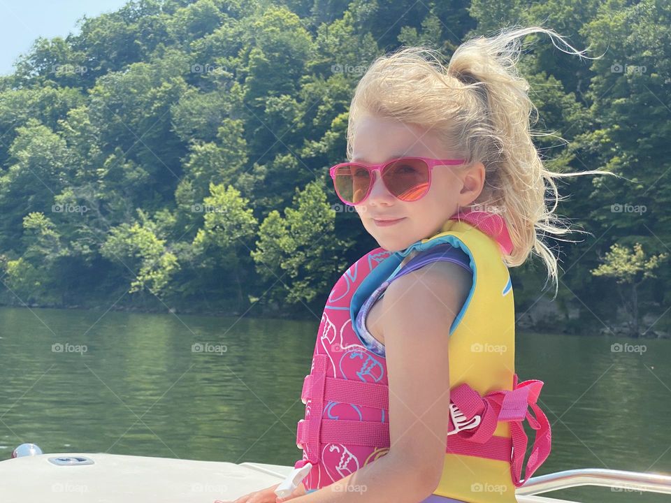 A young girl enjoying the summer day out on the boat