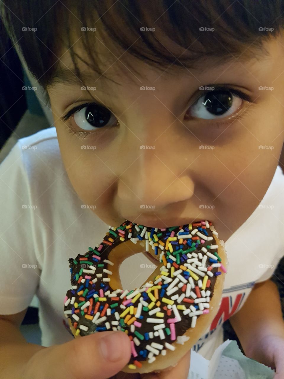 kid eating donut looking at camera