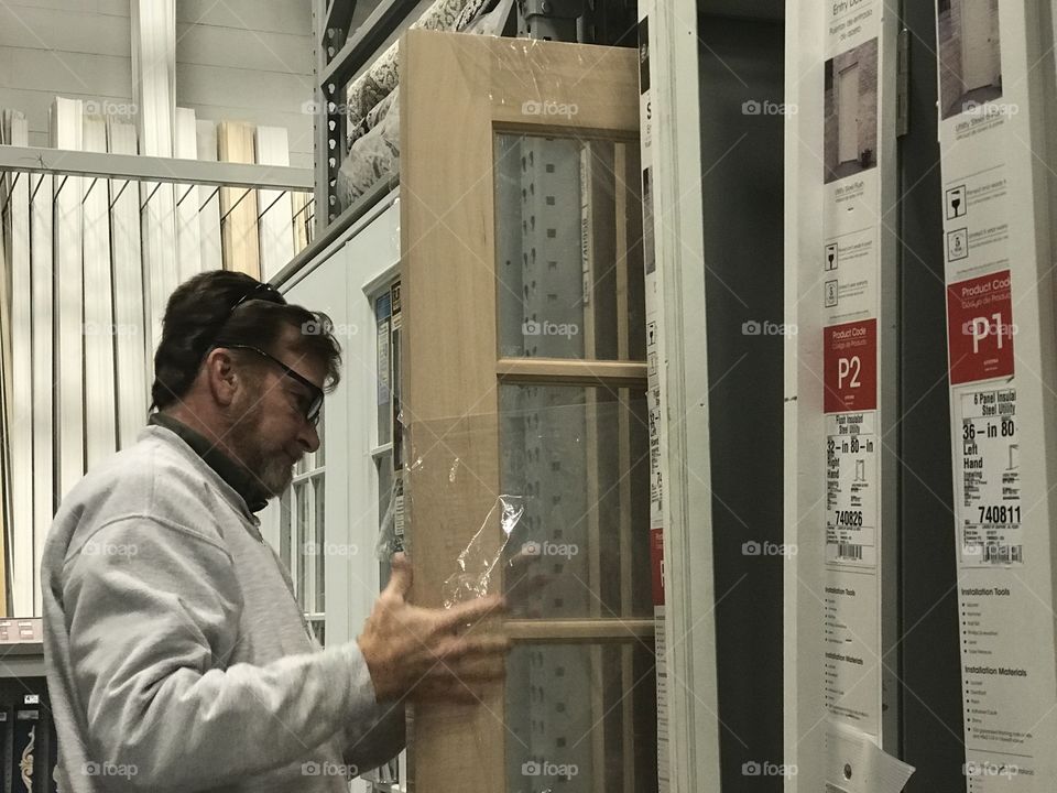 Man retail shopping for a door for a home or house 
