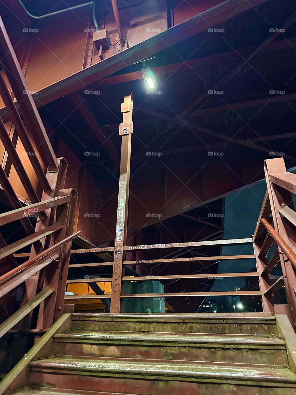 This is the ascending red metal staircase of the “Pulaski Bridge” at “Newtown Creek” on the “Greenpoint”, Brooklyn side of the bridge leading up to the pedestrian lane. 2023. Hypnotic Productions