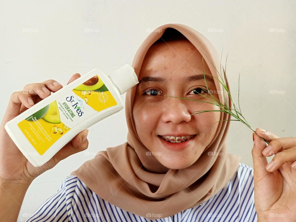 Young woman holding St.Ives products