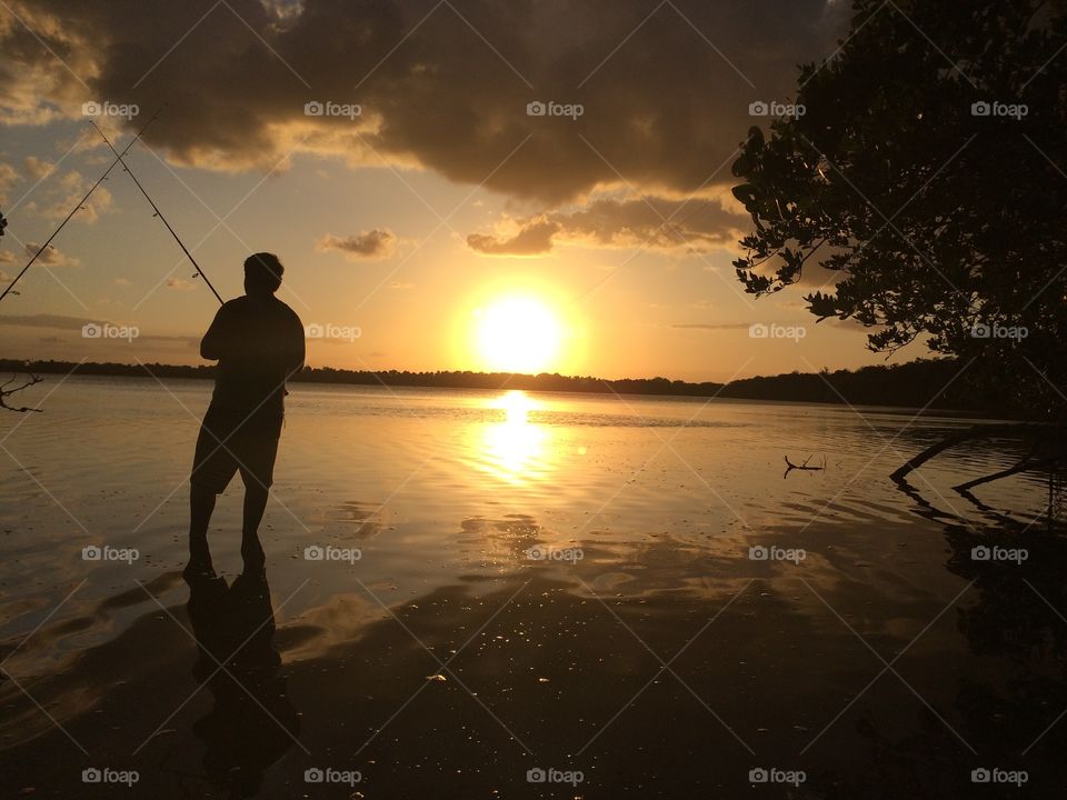 Silhouette man fishing in the sea