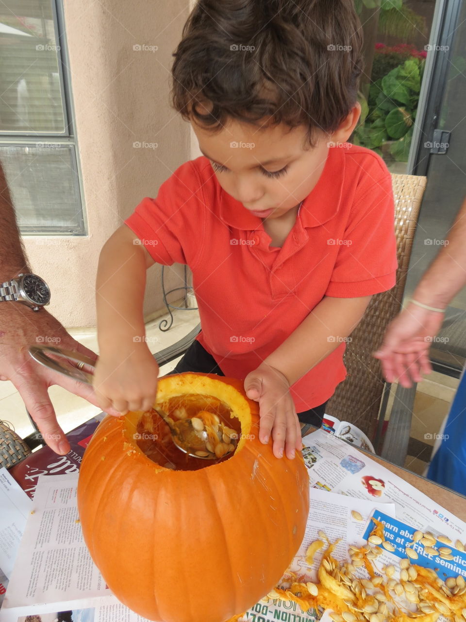 Child scooping out pumpkin.