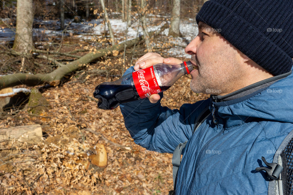 man drinks Coca Cola