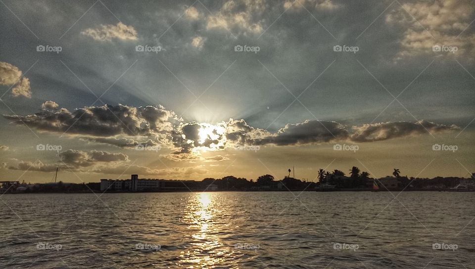 Almost sun down in New York City. The sky and clouds was beautiful. The sunlight, ocean, building in the city.