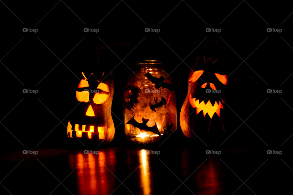Two evil pumpkins with bats in the dark