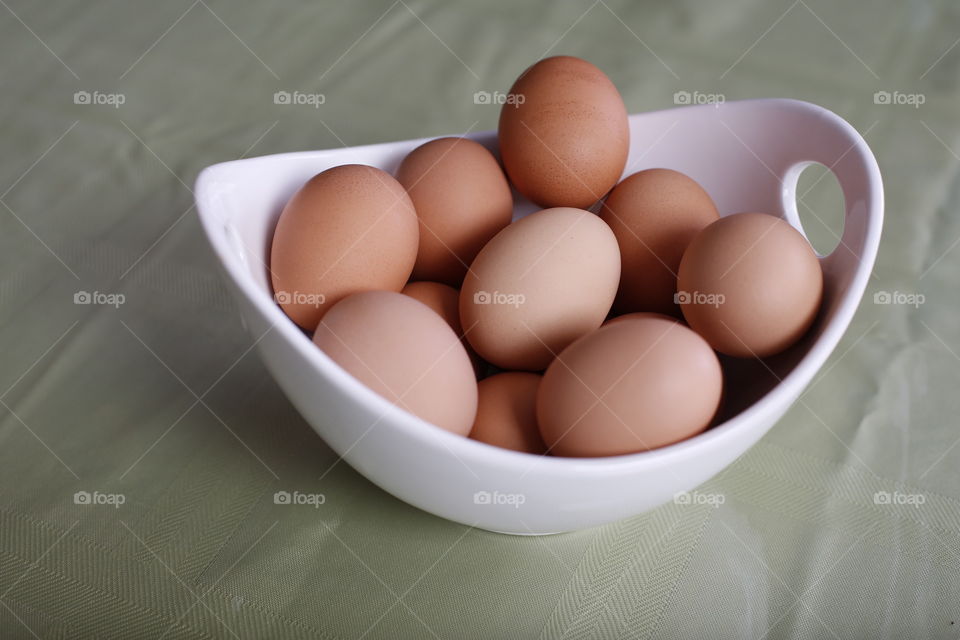 Organic chicken eggs brown in white bowl
