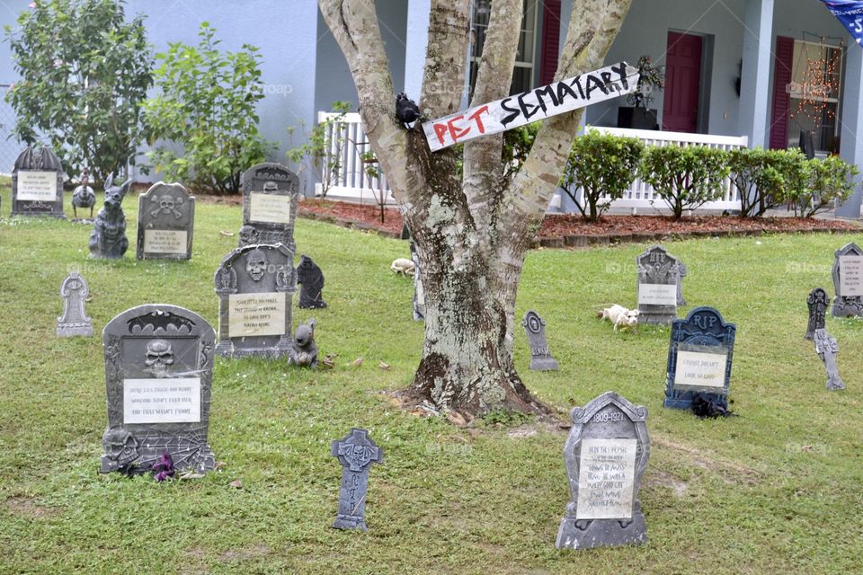 Pet Semetary Halloween decorations in a yard with tombstones and a sign