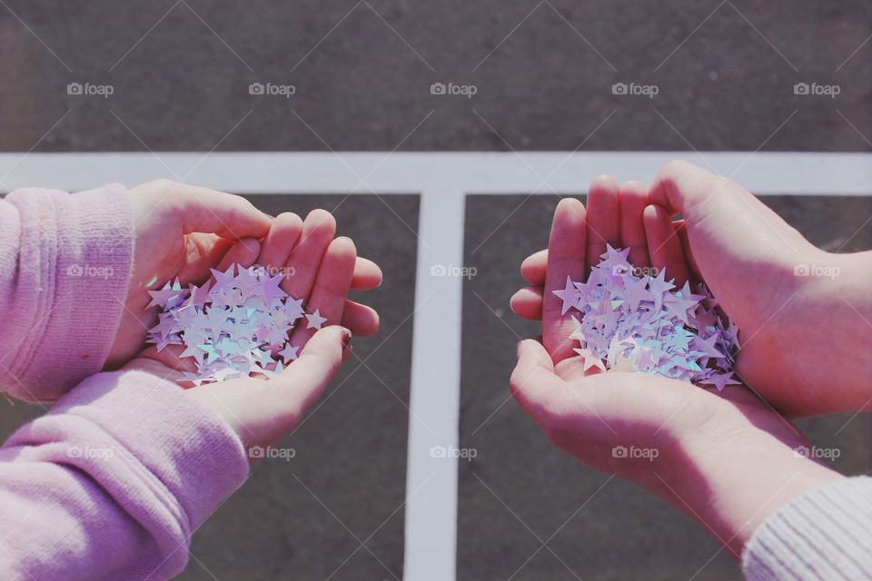 Close-up of hands holding star confetti
