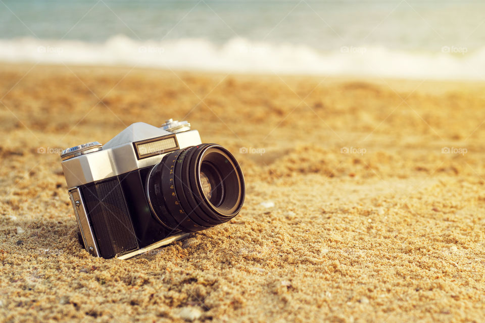 Retro camera in the sand on a beach