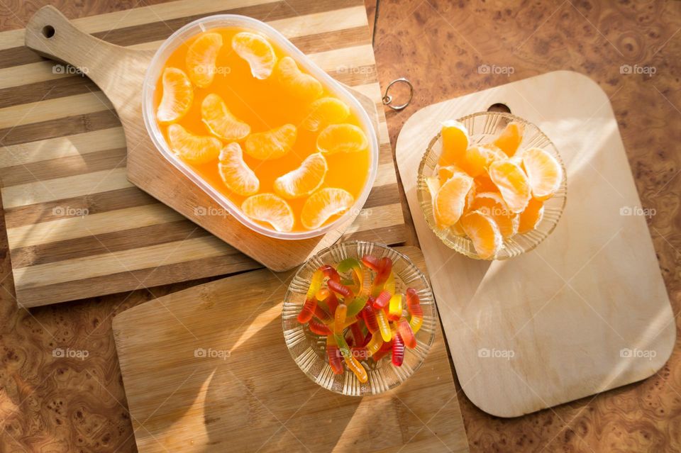 Delicious orange jelly with tangerine slices in a container and jelly worms.