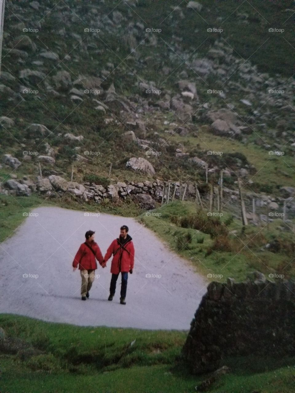 Although they are small, this hiking couple dominates the scene because of their bright red jackets and because they are located in the brightest area of the frame, to which the eye is naturally drawn.