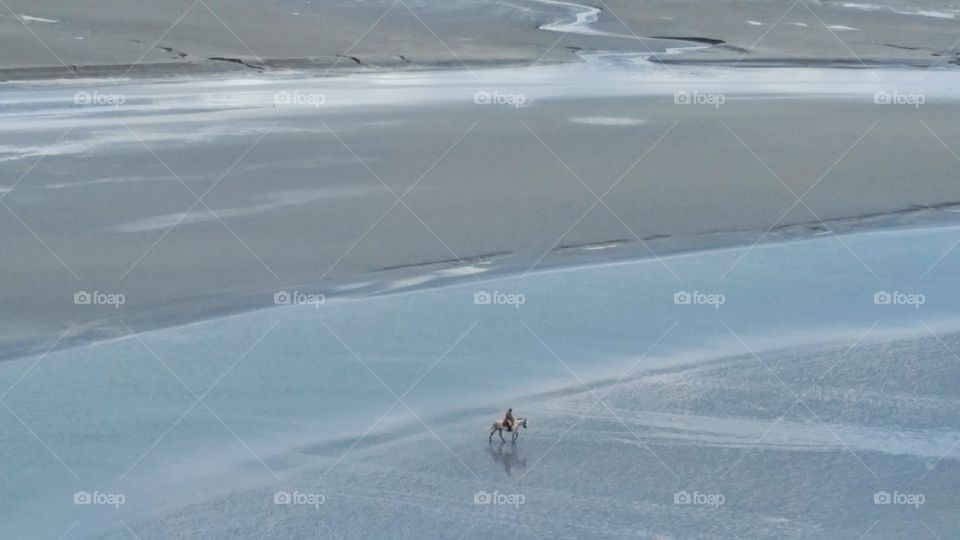 People riding horse on beach