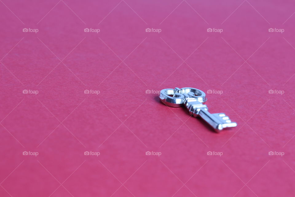 Miniature key on red background