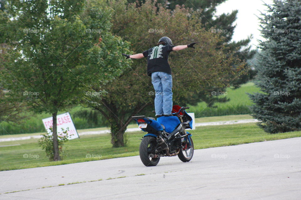 Motorcycle stunt rider. Sport bike stunt rider performing tank stander