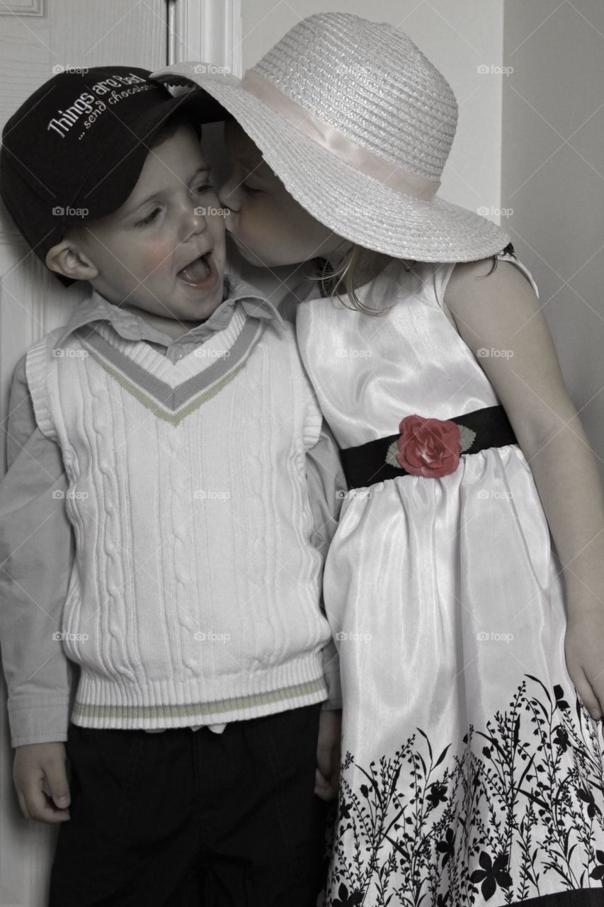 Cute sister kissing her brother on cheek