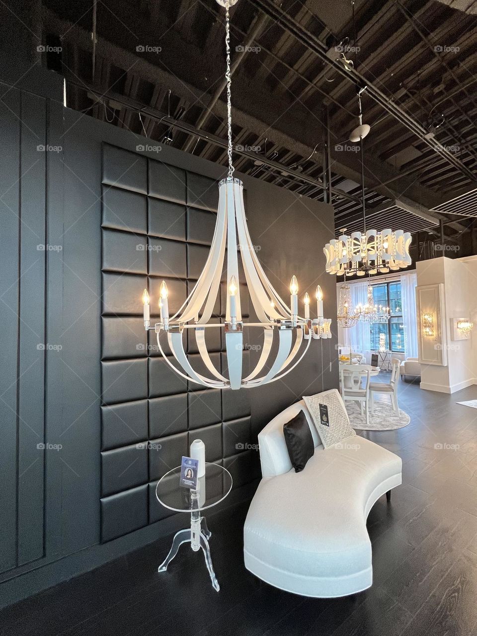 Lighting design, chandelier with white leather straps above boucle rounded setee. 