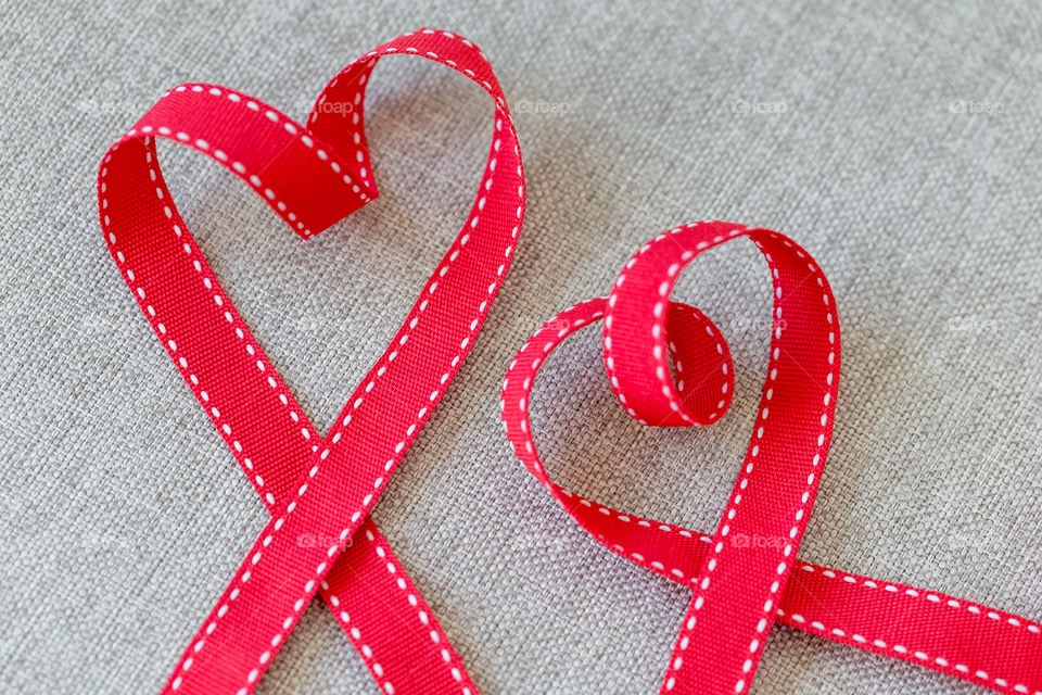 Two hearts made of red textile ribbon