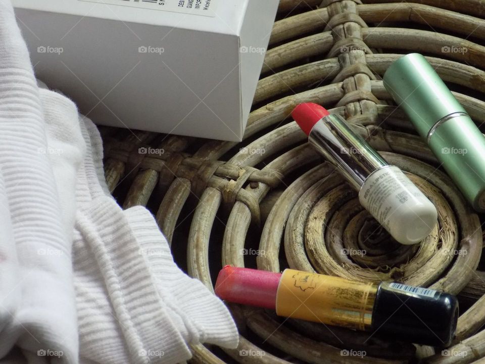 Lipstick, cloth and women's jewelry box on a brown bamboo table