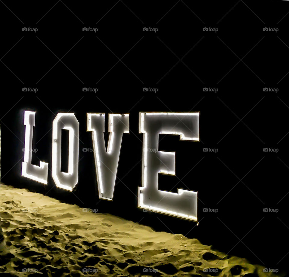 Love is love. Illuminated love sign on a sandy beach in the Dominican Republic.  The night was pitch black except for this sign. 