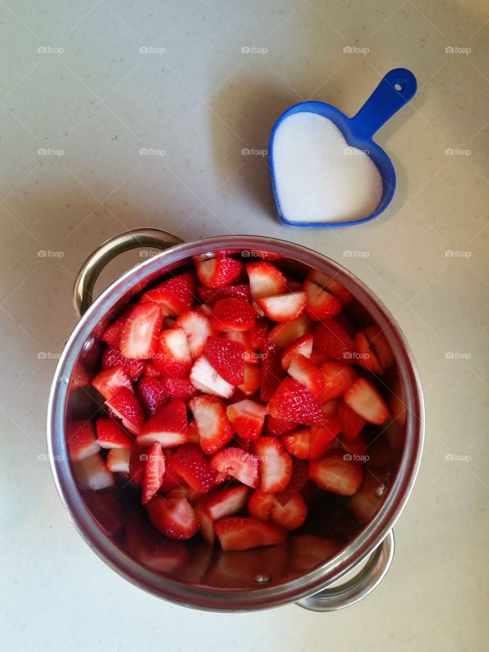 Strawberries in pot with measured sugar on side