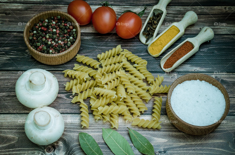 Raw pasta with ingredients and wooden accessories