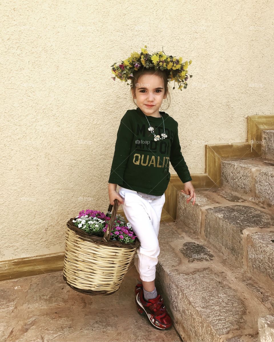 Little girl holding basket of flower