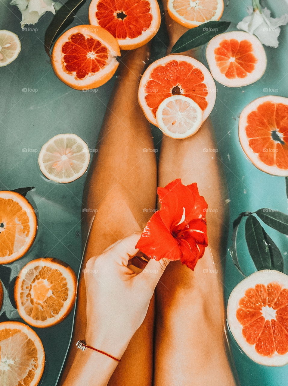 girl in the bath holds a flower