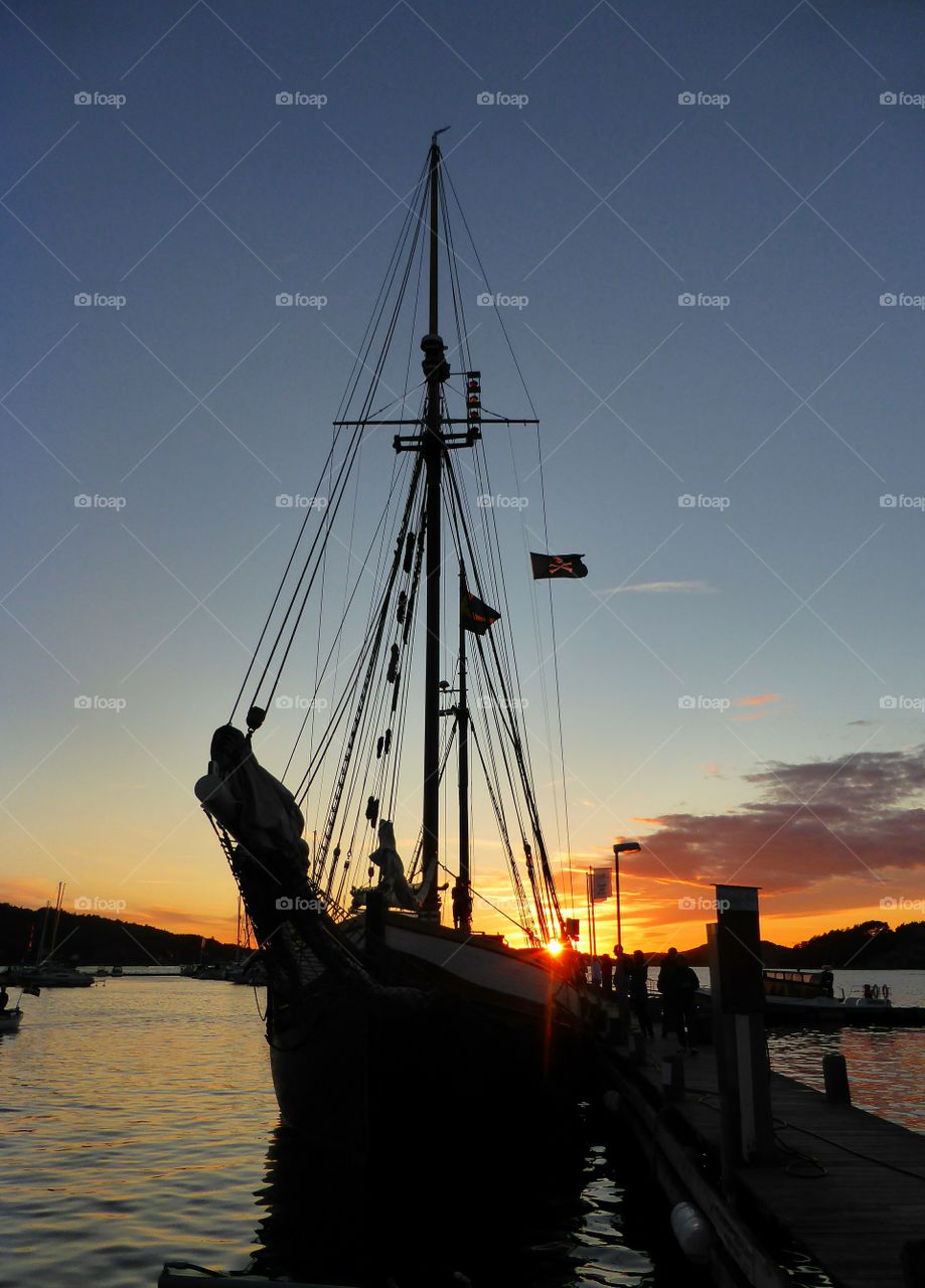 silhouettes of a sailing boat in the dawn