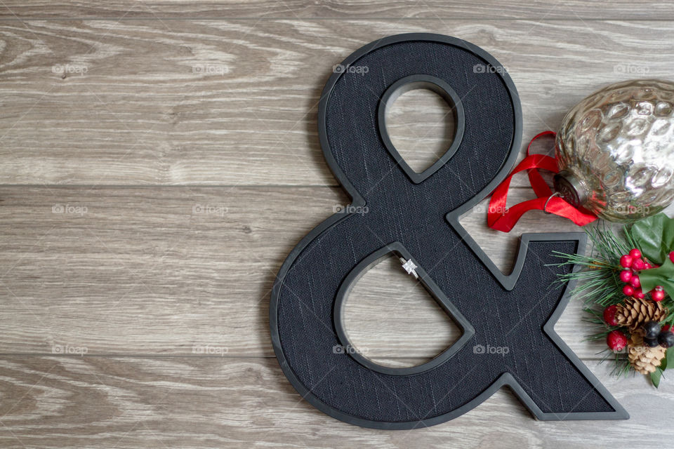 Diamond engagement ring styled on an ampersand with holiday decor