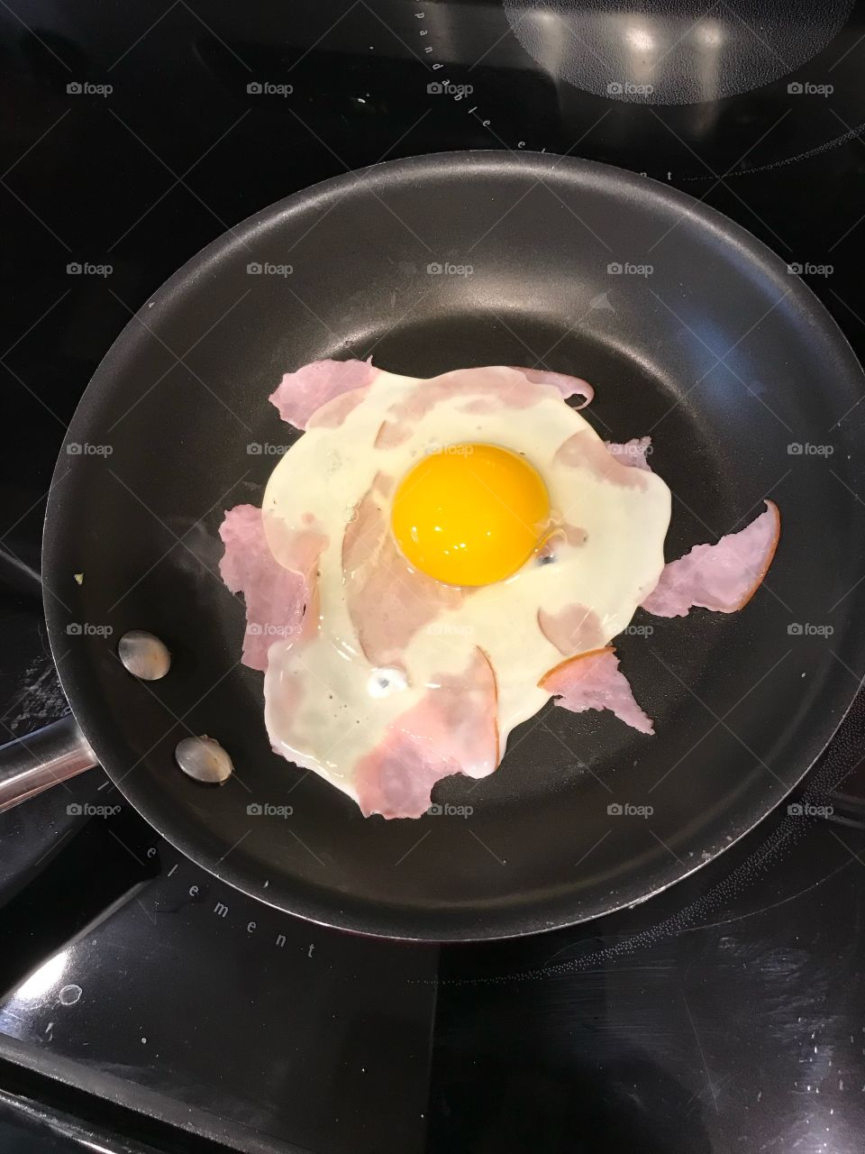 Frying an egg in a pan Where ham