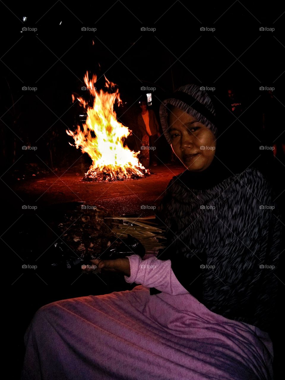 Woman sitting near camp fire