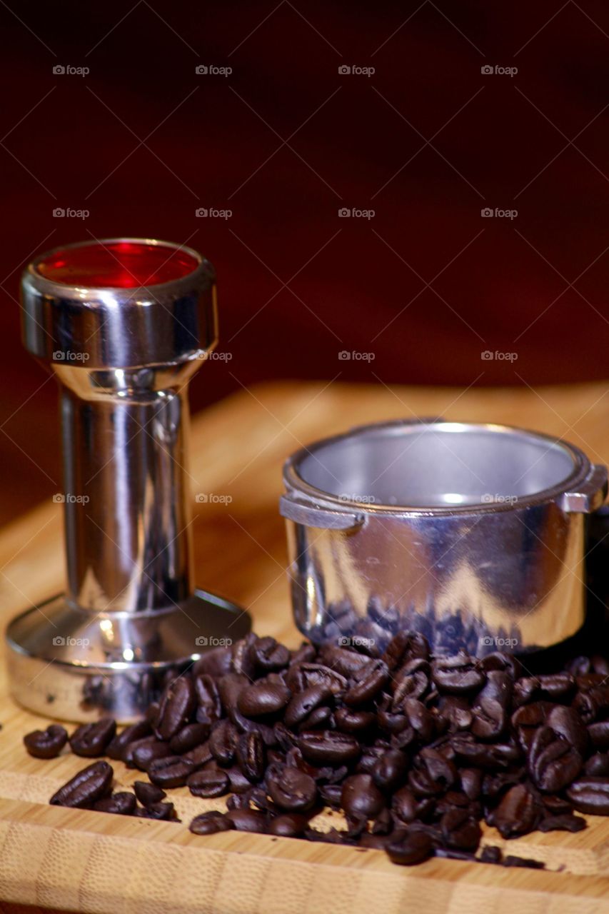 Whole coffee beans with espresso press and brewing basket. 
