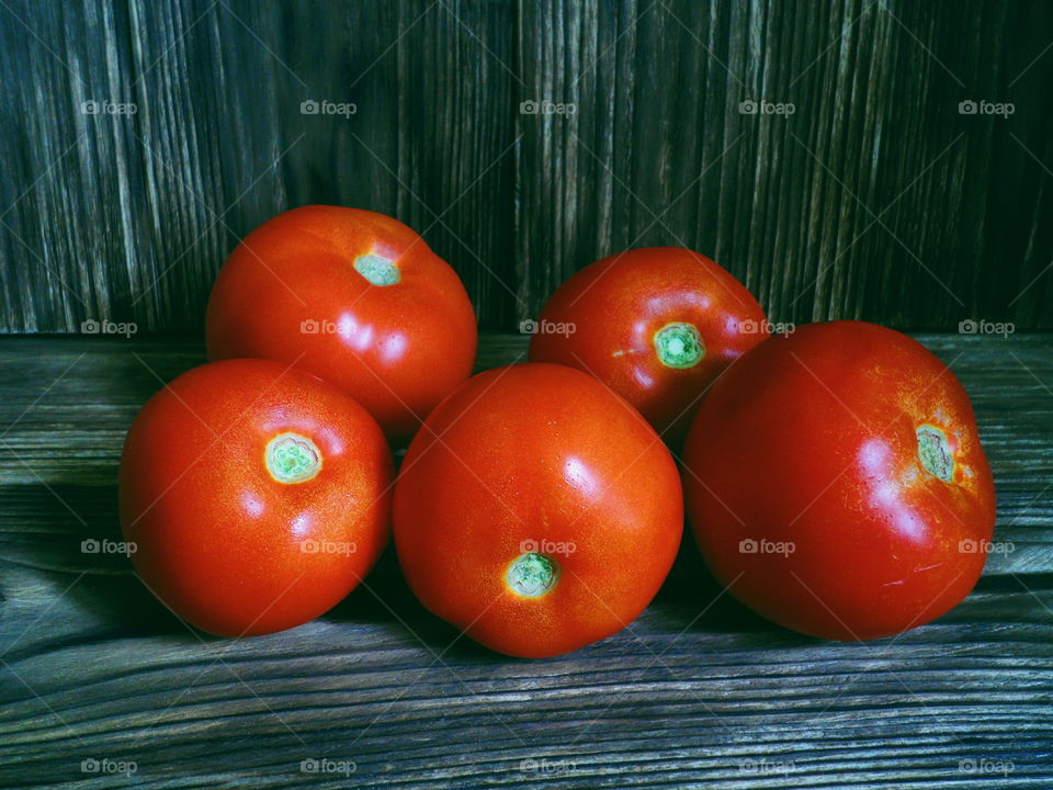 red tomatoes on the burnt boards