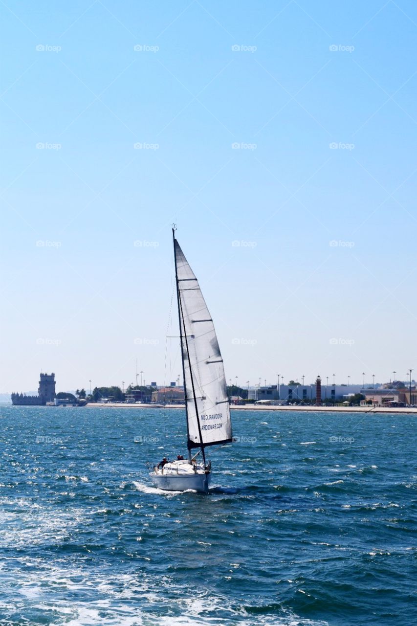 Sailing on beautiful day belem tower in the background on a taguus river in Portugal 