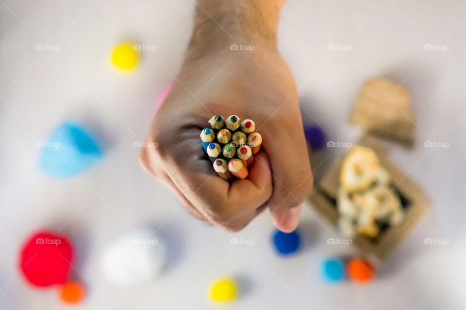 Hand holding colourful pencils