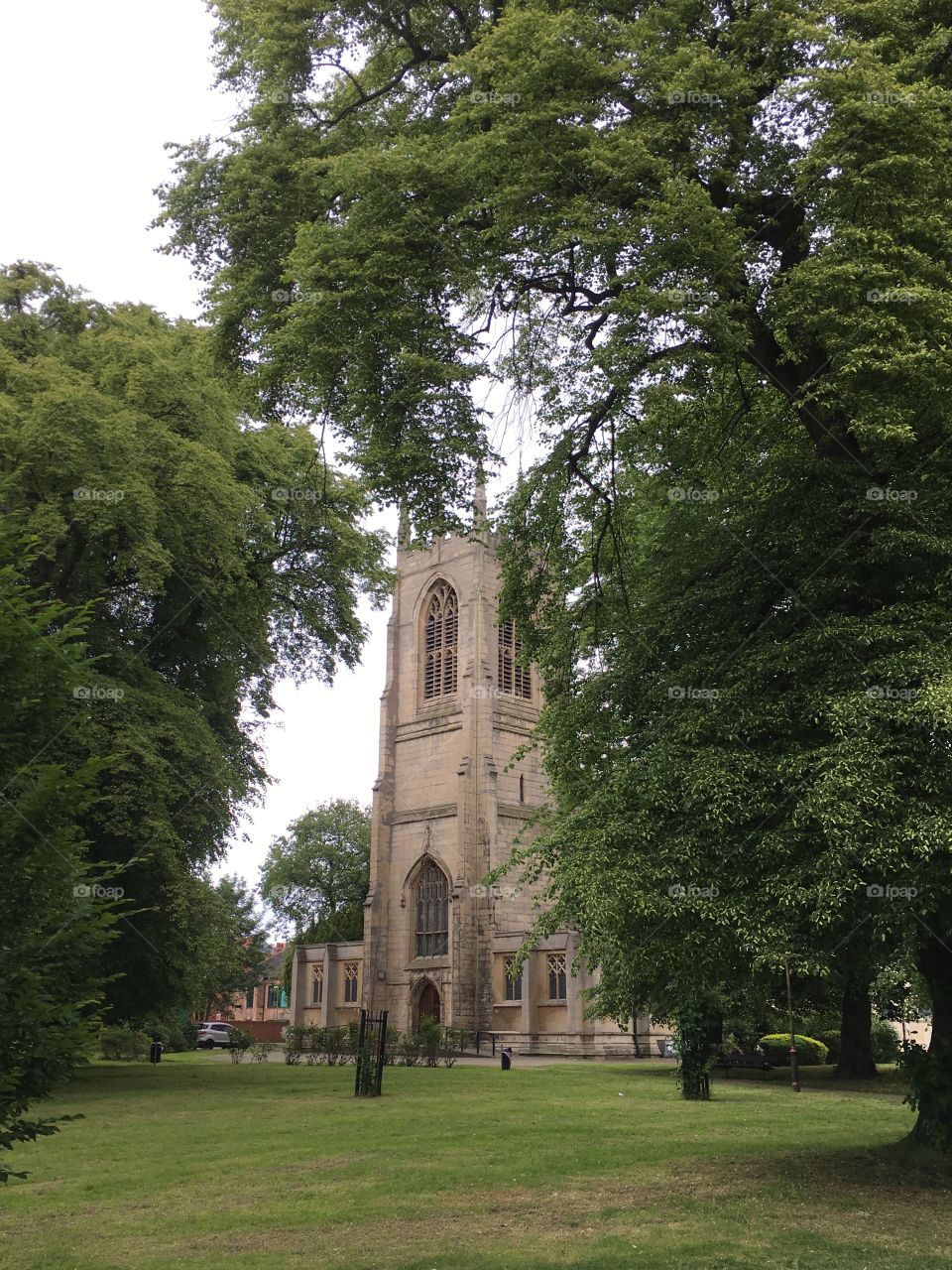 All saints church in Gainsborough, England with 15th century mediaeval tower, surrounded by trees